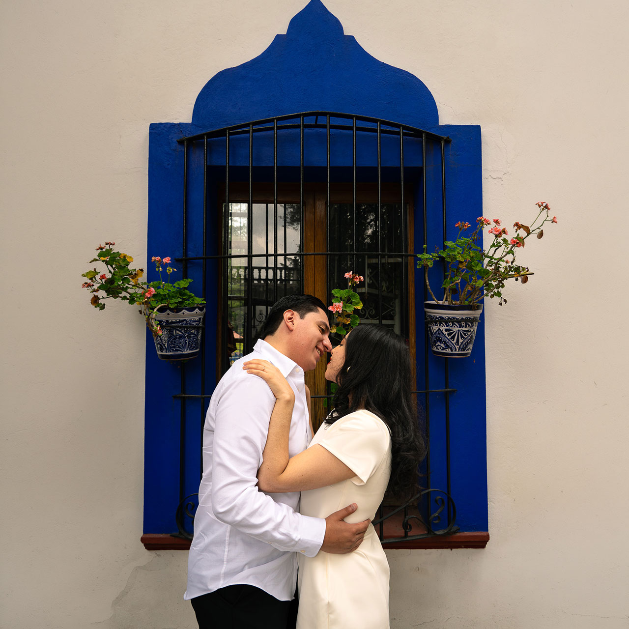 Jessy y Rubén frente a una ventana azul